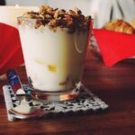 Colazione sana con latte, cereali e frutta, simbolo di un buon metabolismo.