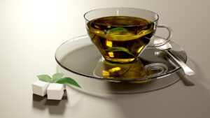 Tazza di tè verde fumante con foglie fresche, ideale per bruciare grassi in 5 minuti.